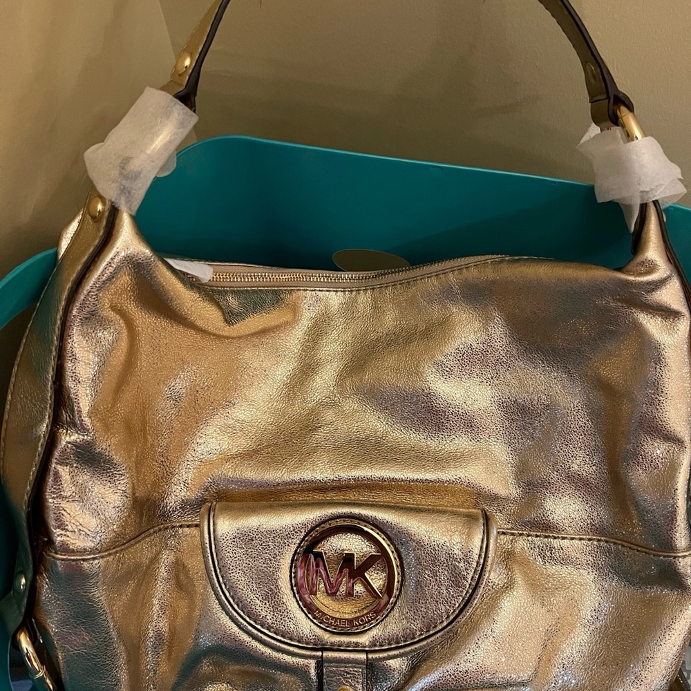 Michael Kors Gold Shoulder Bag with Circular Emblem and Flap Closure